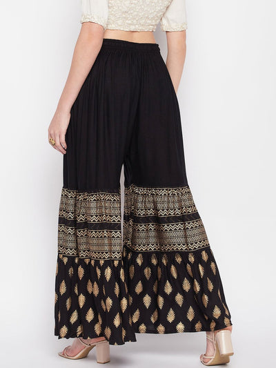 Black printed rayon flared gharara with elasticated waistband and drawstring.