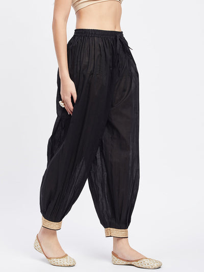Black embellished Afghani salwar with elasticated waistband and embellished hemline.