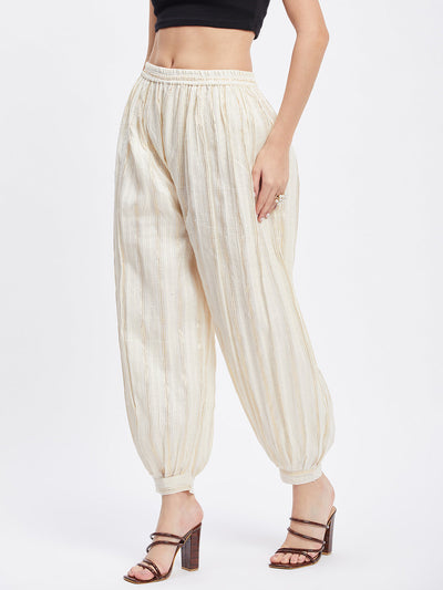 Off-white embellished golden self design Afghani salwar with elasticated waistband.