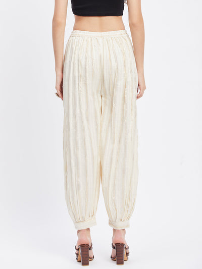 Off-white embellished golden Afghani salwar with self design and elasticated waistband.