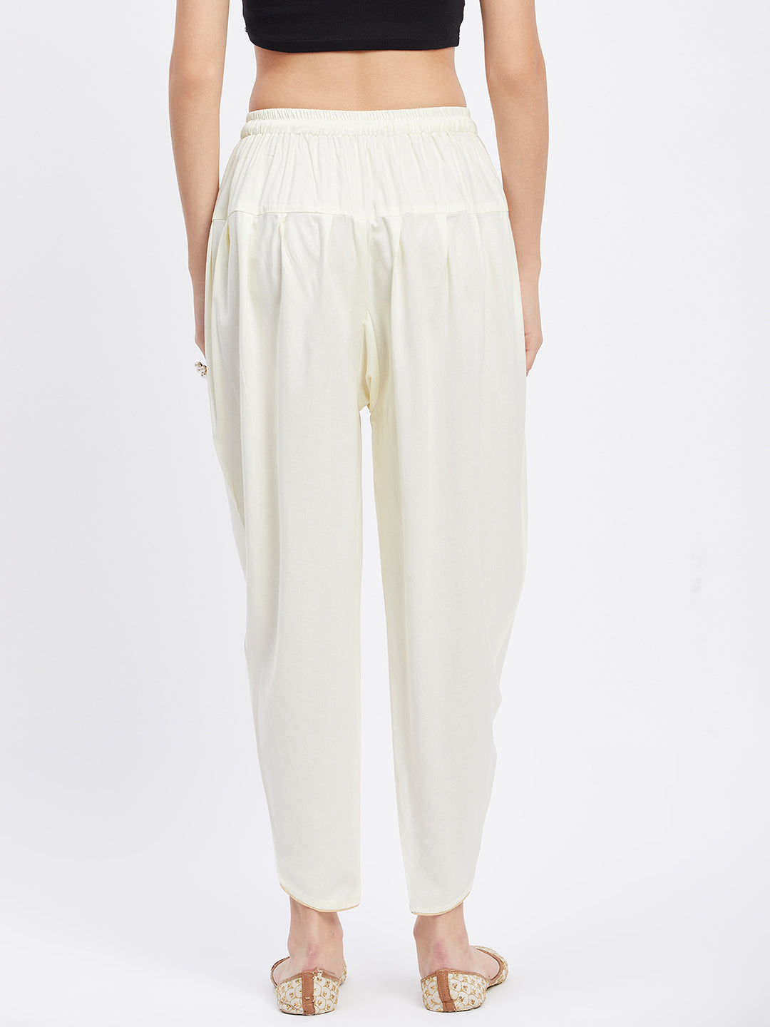 Cream solid rayon tulip pant with elasticated waistband and drawstring.