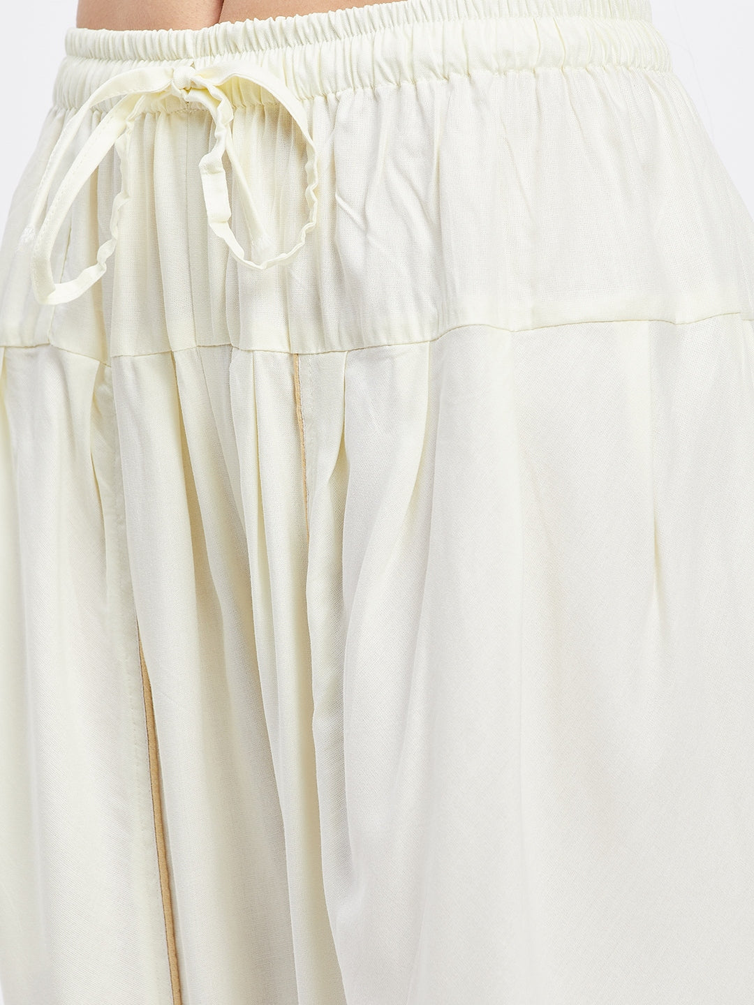 Cream solid rayon tulip pant with elastic waistband and drawstring.
