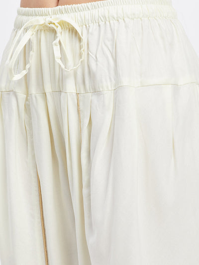 Cream solid rayon tulip pant with elastic waistband and drawstring.