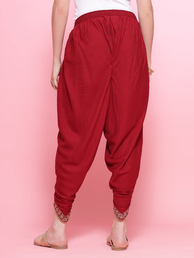 Maroon embroidered rayon dhoti pants with elastic waistband and embellished border.