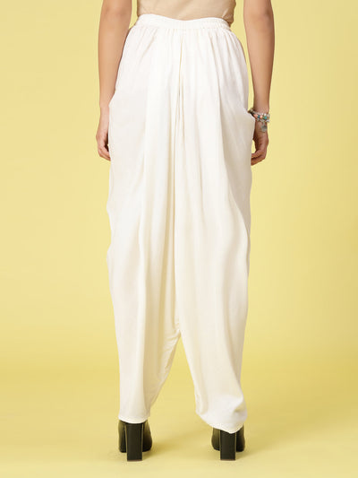 Women solid rayon dhoti salwar with elasticated waistband and curved hemline.