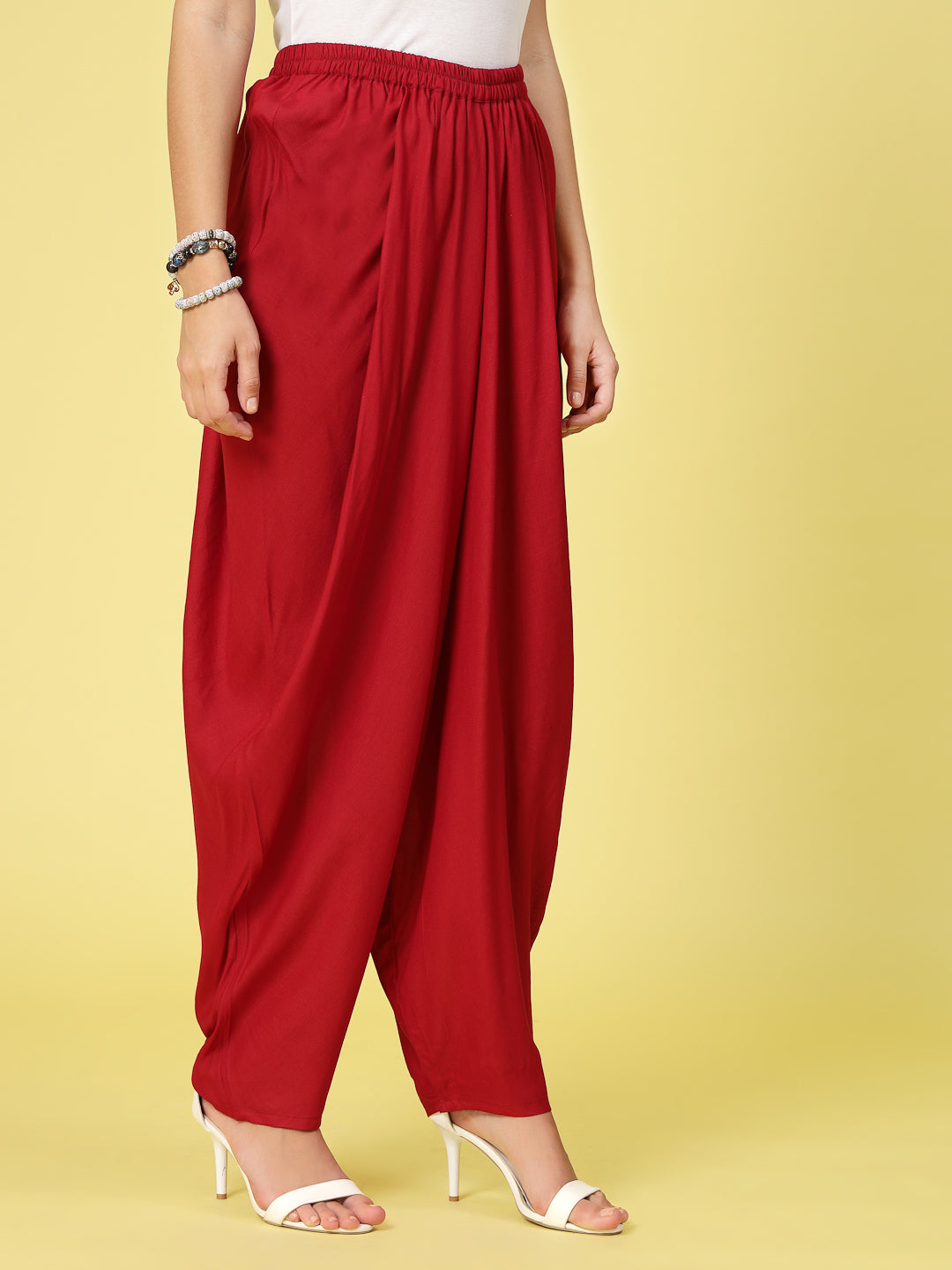 Women solid rayon dhoti salwar with elasticated waistband and curved hemline.