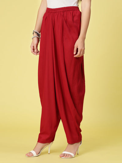 Women solid rayon dhoti salwar with elasticated waistband and curved hemline.