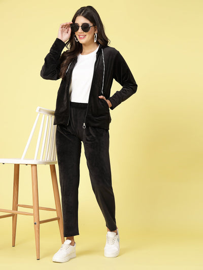 Women wearing a black solid hooded velvet co-ord set with long sleeves and elastic waistband.