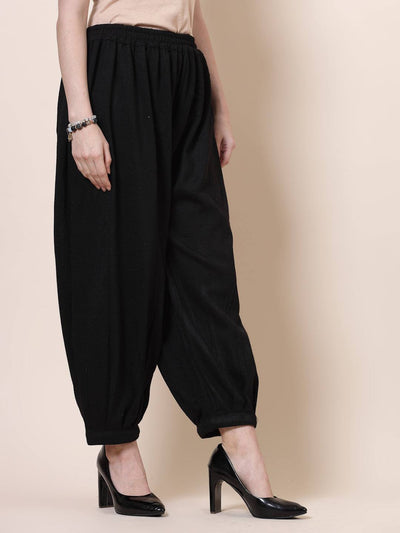Black solid woollen Afghani salwar with elasticated waistband.