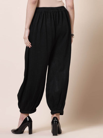 Black solid woollen Afghani salwar with elastic waistband.