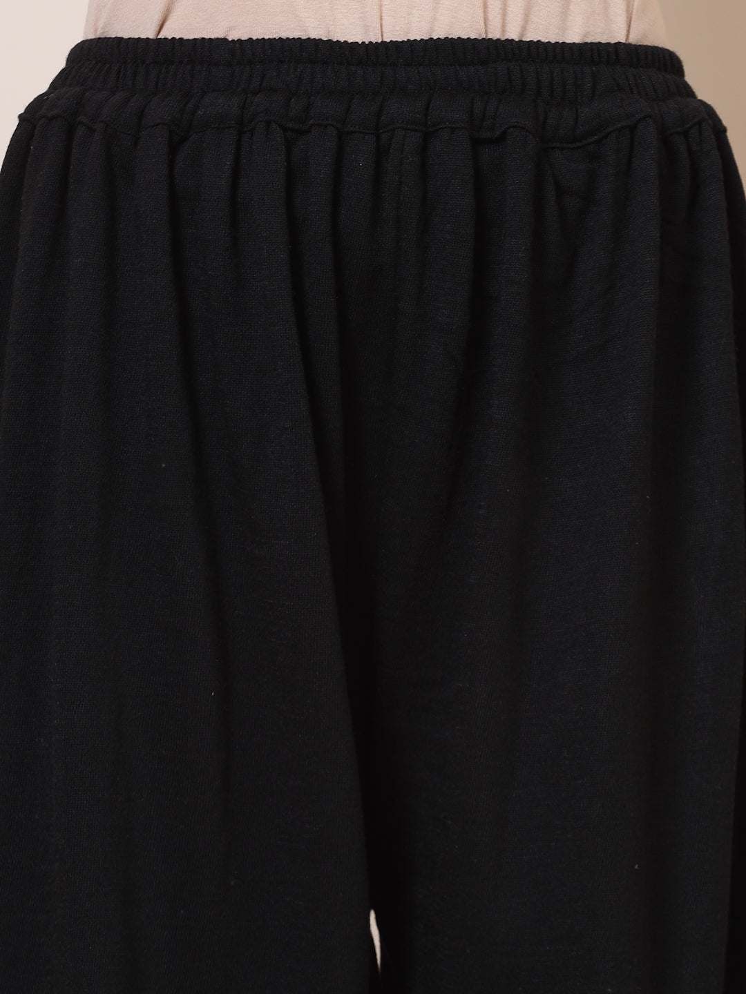 Black solid woollen Afghani salwar with elasticated waistband.