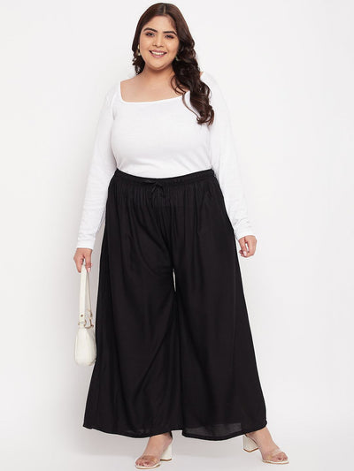 Black Solid Rayon Jumbo Sharara with elasticated waistband and drawstring.