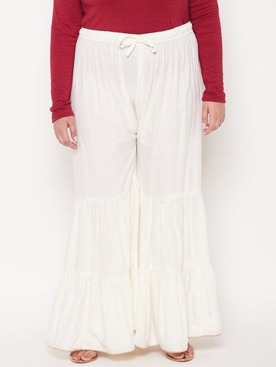Cream solid rayon flared gharara with elasticated waistband and drawstring.