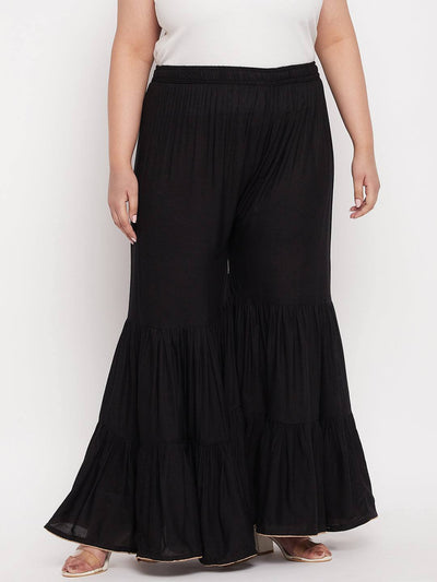 Black solid rayon flared gharara with elasticated waistband.