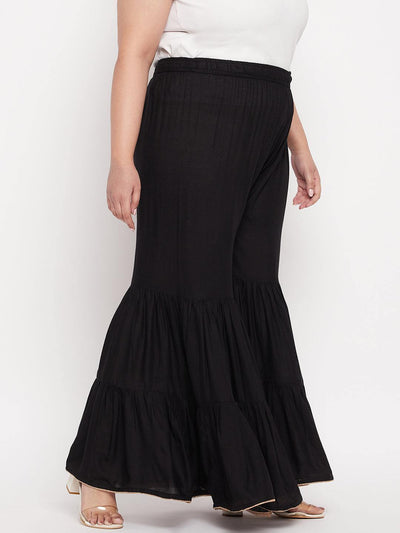 Black solid rayon flared gharara with elasticated waistband and drawstring.