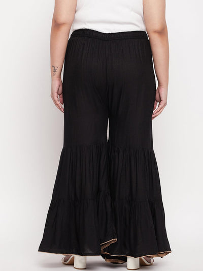 Black solid rayon flared gharara with elasticated waistband and drawstring.