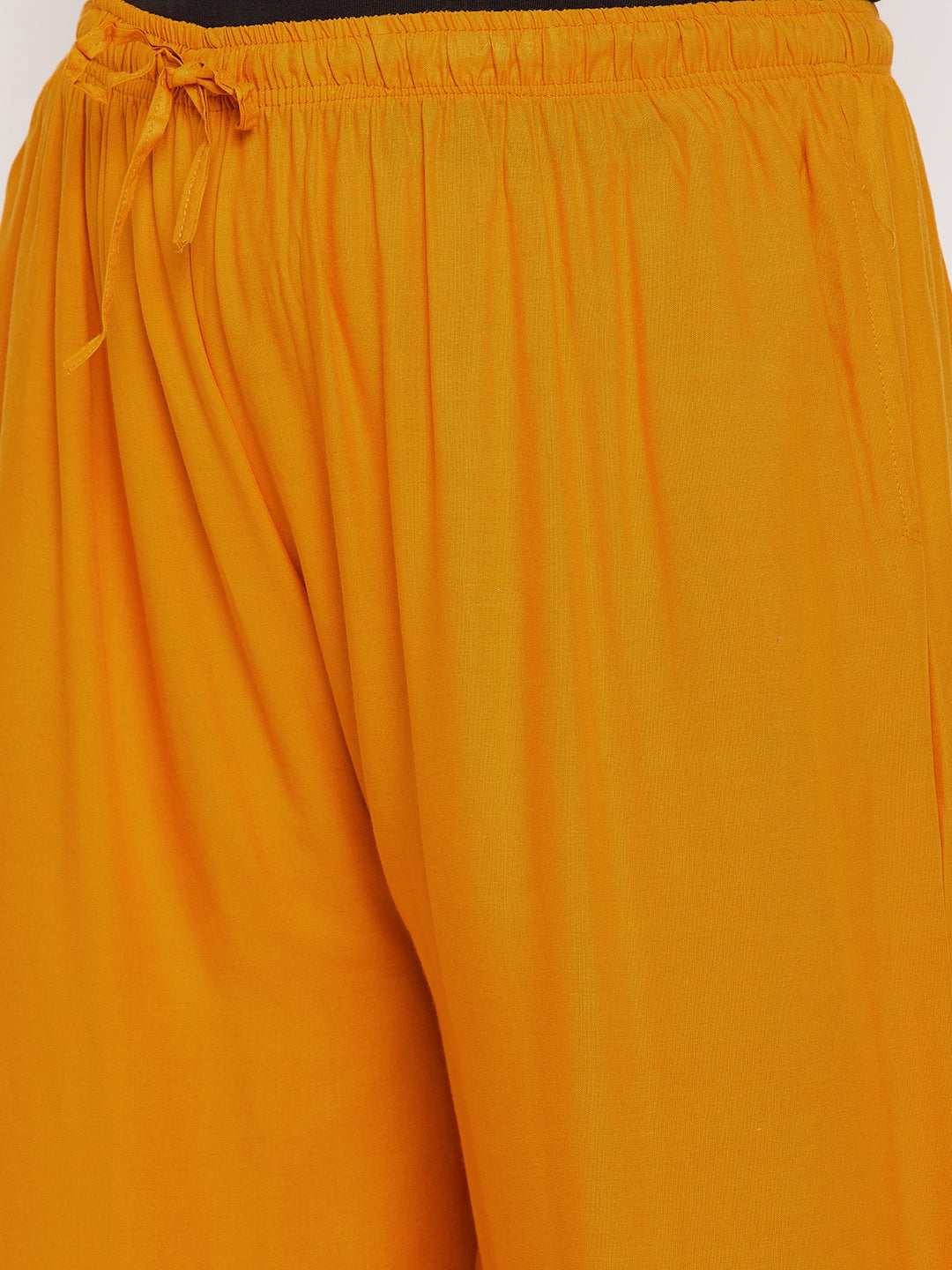 Mustard solid rayon jumbo sharara with elasticated waistband and drawstring.