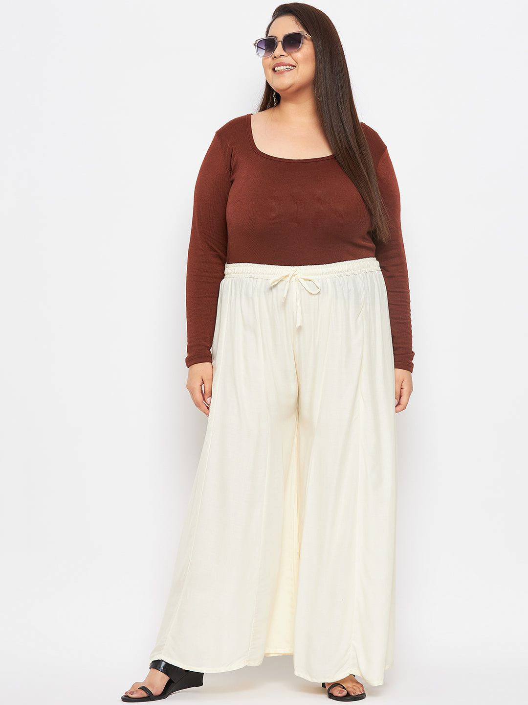 Cream solid rayon flared sharara with elasticated waistband and drawstring.