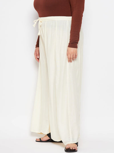 Cream solid rayon flared sharara with elasticated waistband and drawstring.