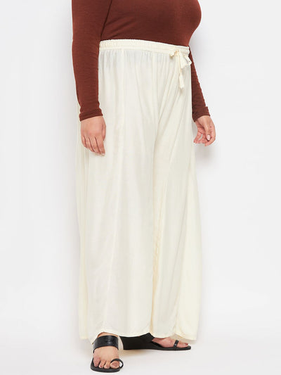 Cream solid rayon flared sharara with elasticated waistband and drawstring.