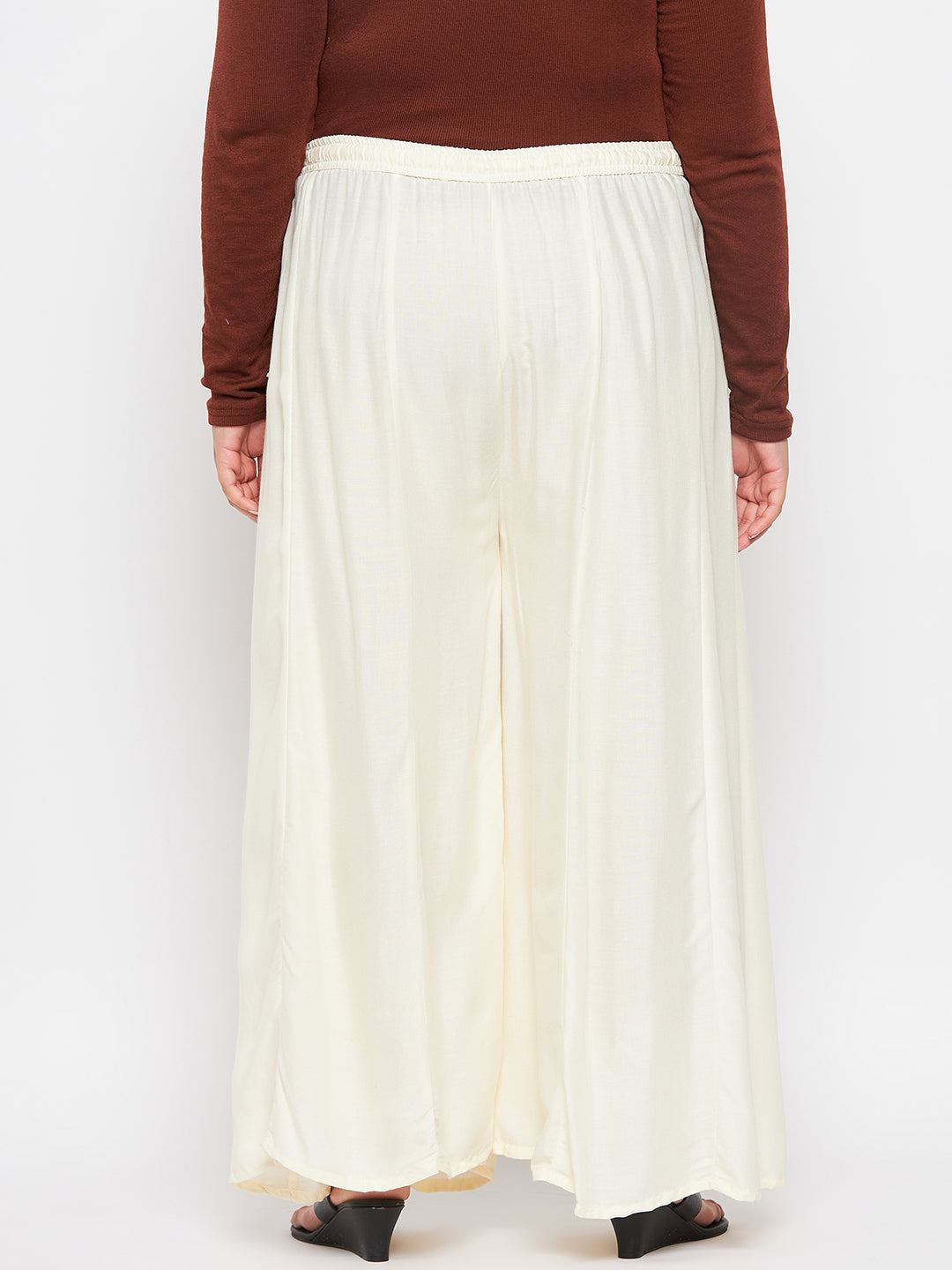Cream solid rayon flared sharara with elasticated waistband and drawstring.