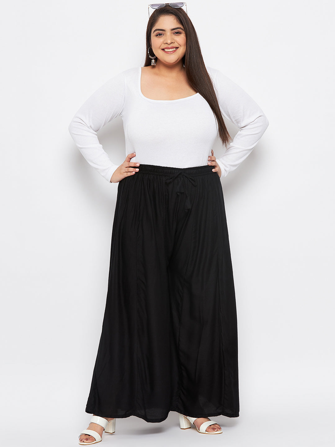 Black solid rayon flared sharara with elasticated waistband and drawstring.