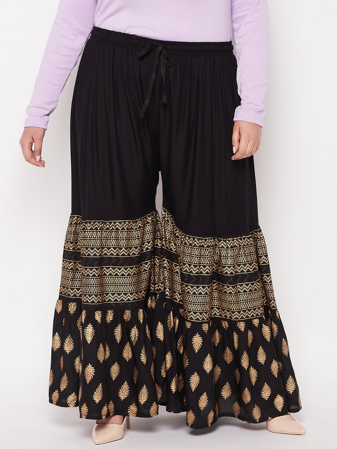 Black printed rayon flared gharara with elasticated waistband and drawstring.