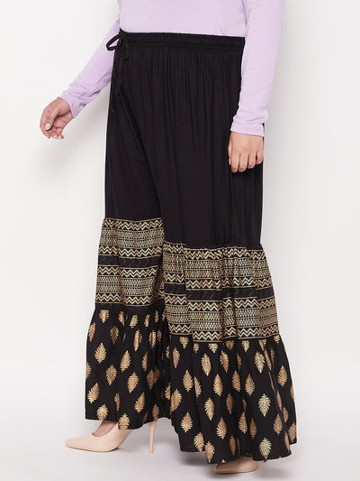 Black printed rayon flared gharara with elasticated waistband and drawstring.